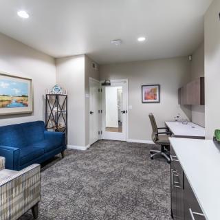 A modern office space featuring a blue sofa, desk, and stylish decor.
