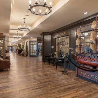 Spacious hallway with chandeliers and a decorative ship model.