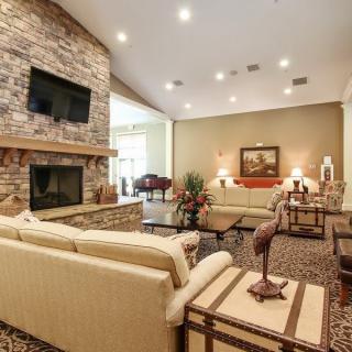 Spacious and elegant living room with a stone fireplace and modern furnishings.