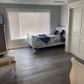 A modern, minimalist bedroom with natural light and wooden flooring.