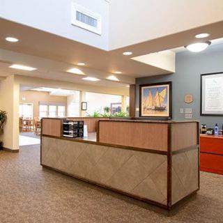A modern office reception area with a central desk and bright lighting.