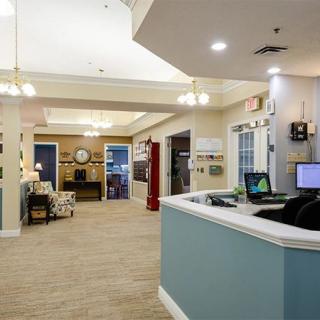 A spacious office reception area with a desk, seating, and hallway visible.
