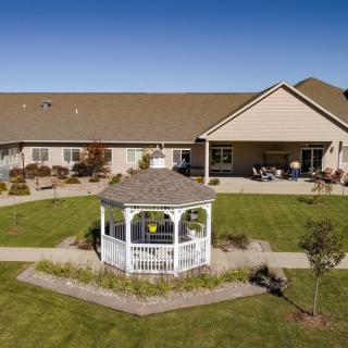 A picturesque house with a well-maintained lawn and a charming gazebo.