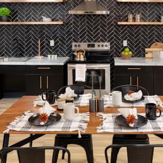 A modern kitchen and dining area featuring a chic black and white color scheme with a stylish table setting.