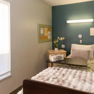 A neatly arranged hospital room with a bed and small table.