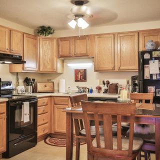 A cozy kitchen with wooden cabinets and a dining area.