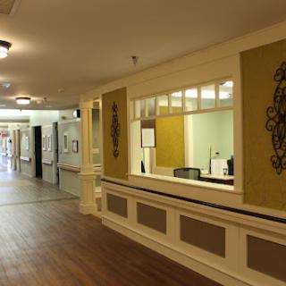 A view of a spacious hallway featuring a reception area with natural lighting.