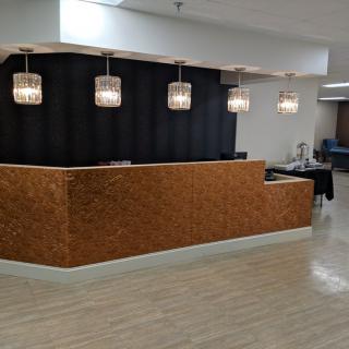 A modern reception area with a stylish counter and pendant lighting.