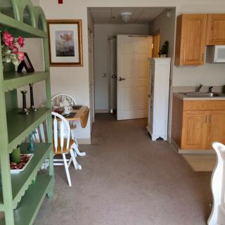 A cozy interior featuring a kitchenette and dining area with wooden furniture.
