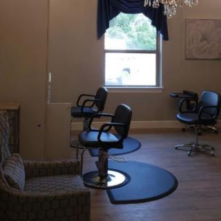 Interior of a hair salon with styling chairs and a large window.