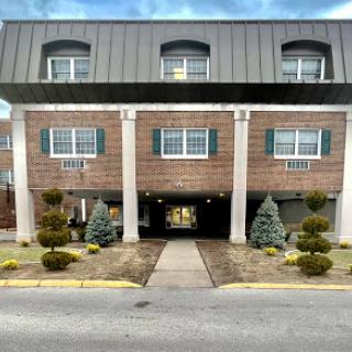 A modern commercial building featuring a distinctive roof design and neatly manicured landscaping.
