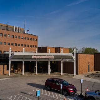 A view of the hospital entrance with a clear sky above.