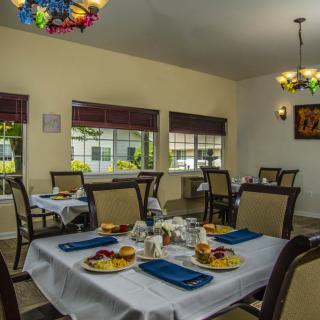 A cozy dining area with elegantly set tables and comfortable seating.