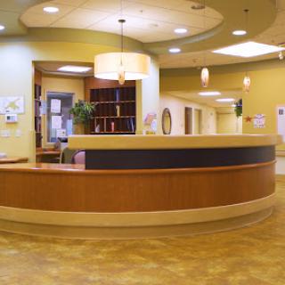 A welcoming reception area in a healthcare facility, featuring modern design and a warm color palette.