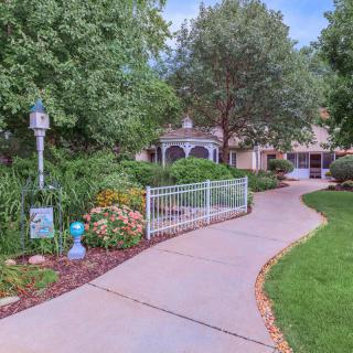 A scenic garden pathway surrounded by lush greenery and flowers.