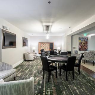 A modern lounge area with comfortable seating, tables, and a television.