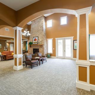 Spacious living area with high ceilings and a fireplace.
