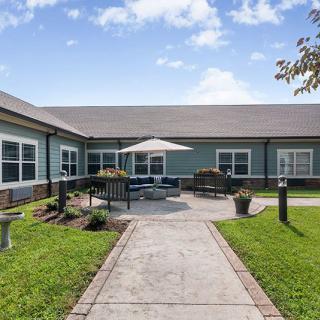 A residential building with a well-maintained courtyard featuring outdoor furniture and landscaping.