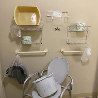 A wall-mounted setup in a medical facility featuring various care-related equipment.