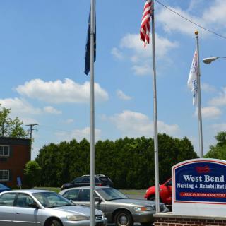 A car dealership with flags and parked cars.