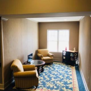 A cozy seating area with two armchairs and a table by the window.