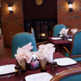 A cozy restaurant interior with elegantly set tables, featuring folded napkins and comfortable chairs.