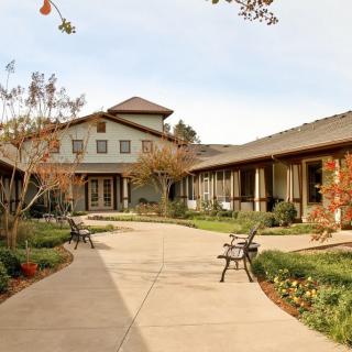 A serene courtyard surrounded by buildings, featuring benches and landscaped greenery.