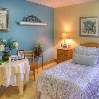 A cozy and well-decorated bedroom featuring soft bedding and personal touches.