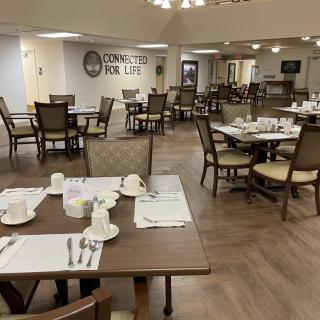 A well-arranged dining area with neatly set tables and chairs, ready for guests.