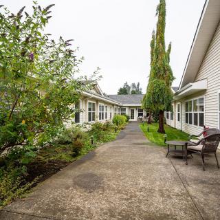 A serene pathway lined with greenery leading to a building entrance.