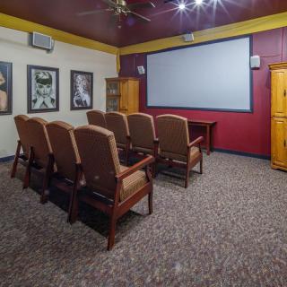 A cozy home theater setup with a large screen and multiple rows of comfortable seating.