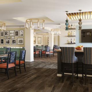 A modern dining area with a mix of tables, chairs, and a bar counter, complemented by decorative lighting and artwork on the walls.