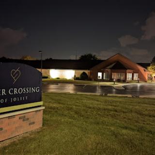 A nighttime view of a building with a prominent sign in front.