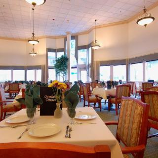 An elegant dining room with neatly arranged tables and chairs, featuring sophisticated decor and ambient lighting.
