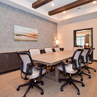 A modern conference room with a large meeting table and office chairs.