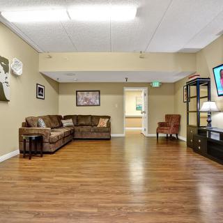 A cozy living room with a sectional sofa, wooden flooring, and modern decor.