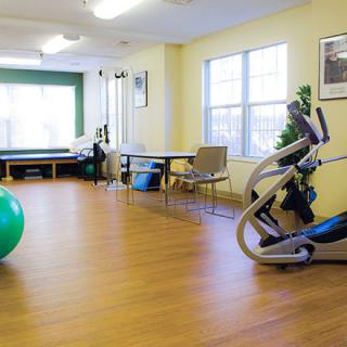 A well-equipped fitness room with exercise machines and a large exercise ball.