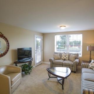 A cozy living room with a sofa, TV, and coffee table by the window.