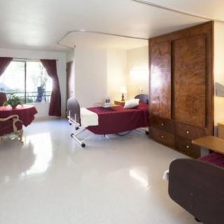 A spacious hospital room with patient beds and comfortable furnishings.