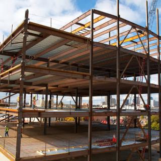 A partially constructed steel building with scaffolding in place.