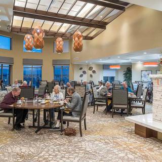 A spacious and well-lit dining area with tables occupied by people enjoying a meal.