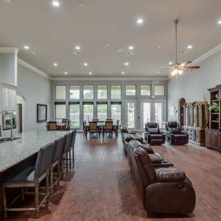 Spacious open-concept living and dining area with modern kitchen island and large windows.