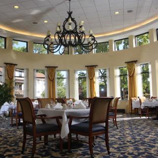 A beautifully designed dining room featuring elegant decor and ample natural light from large windows.
