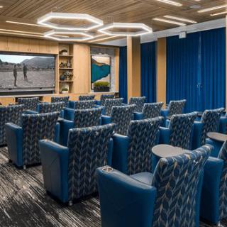 A modern home theater with comfortable seating and a large screen for viewing.