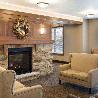 A cozy living room with a stone fireplace and comfortable seating.