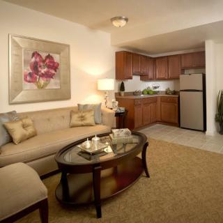 A cozy open-concept living room and kitchen space with warm lighting and modern furnishings.