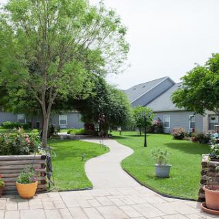 A serene garden pathway leads through a lush green landscape, inviting relaxation and tranquility.
