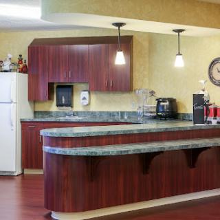 A modern kitchen featuring wooden cabinets, a granite countertop, and various appliances.