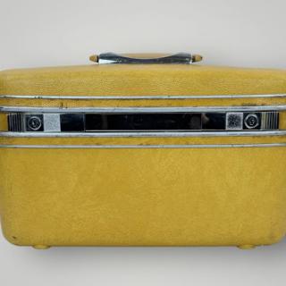 A vintage yellow suitcase, perfect for nostalgic travels.