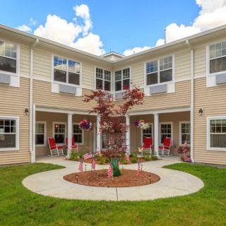A residential building with a landscaped courtyard under a partly cloudy sky.